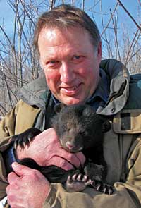 Glenn Moberg with dark furry bear cub