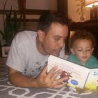 A 413 Families participant reads to his child.