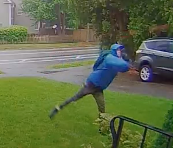Screenshot from a video showing a man throwing a brick at the home of a New Hampshire Public Radio journalist