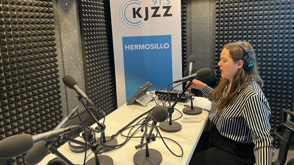 Nina Kravinsky speaks into a mic as she works in a studio at the Hermosillo news bureau.