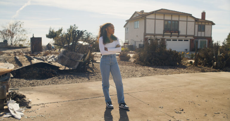 Host Maiya May stands in front of a hardened home in Palisades, Calif., during filming of ”Weathered: Inside The LA Firestorm.”