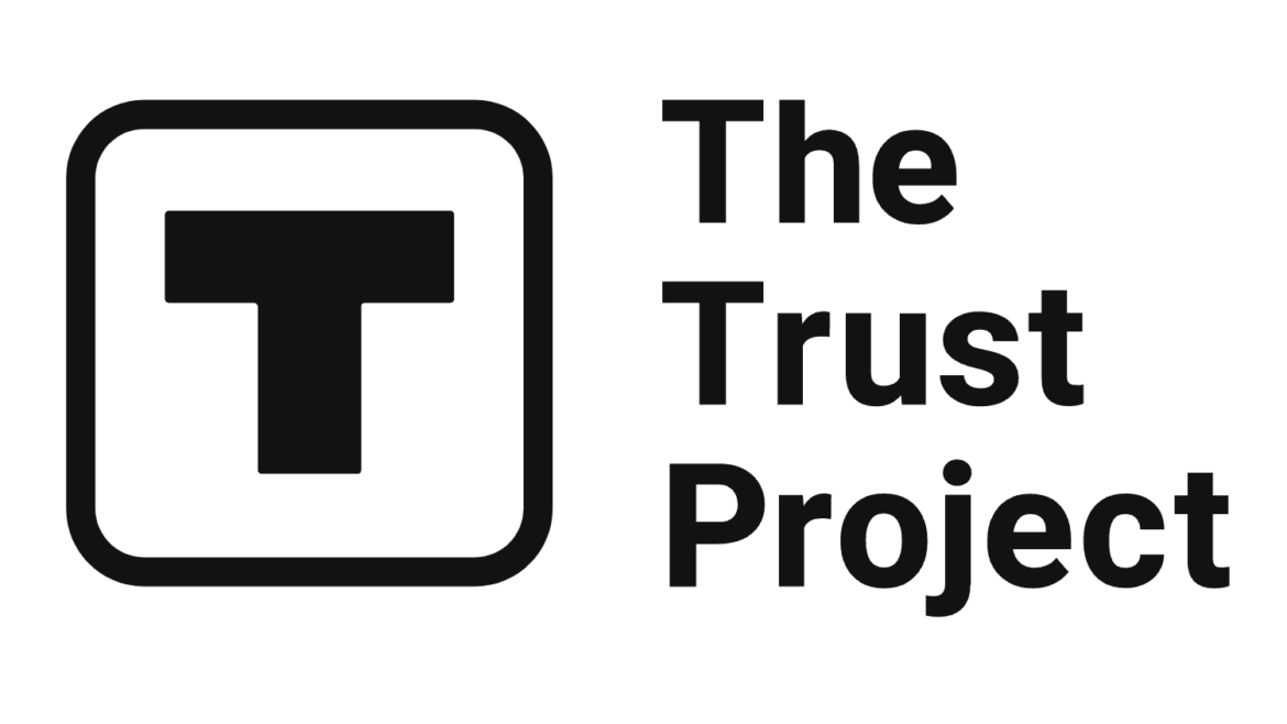 Logo of The Trust Project, featuring a bold, black capital ‘T’ inside a rounded square, followed by the words ‘The Trust Project’ in black, bold font on a white background.