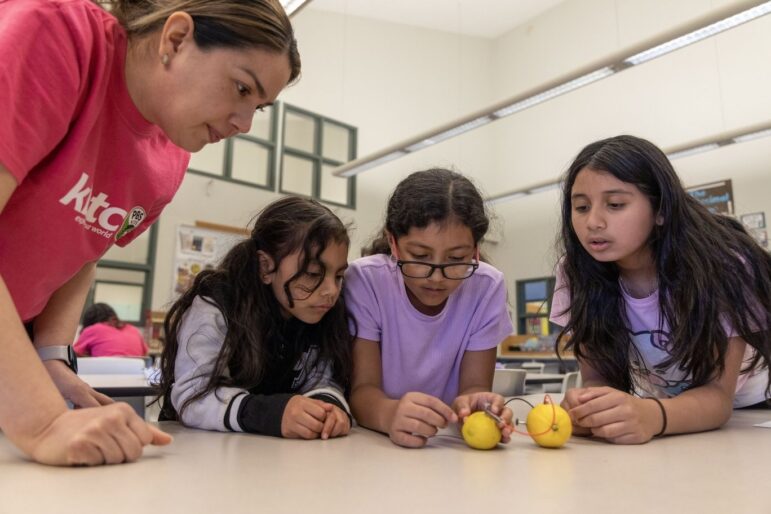 Students work on an experiment involving a lemon battery.