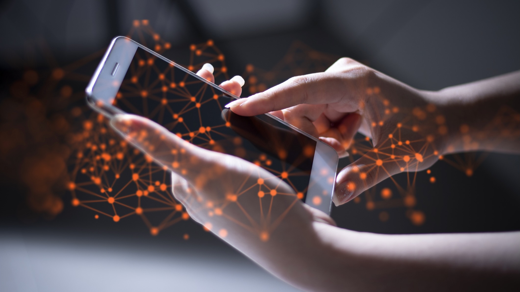 Close-up of hands using a smartphone, with an overlay of orange digital network nodes and connections symbolizing communication or information flow in a connected ecosystem.