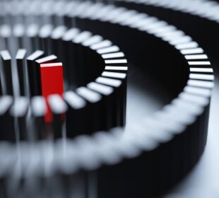 A conceptual image of a red domino at the center of a whirlpool-patterned chain of black dominos.