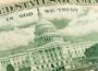 Close-up of the U.S. Capitol building as it appears on U.S. currency, showing detailed engraving with the words “In God We Trust” above.