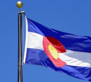 The Colorado state flag flying against a blue sky