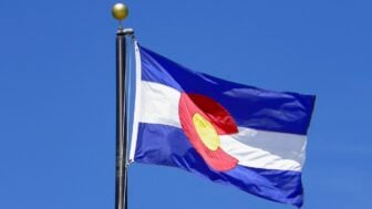 The Colorado state flag flying against a blue sky