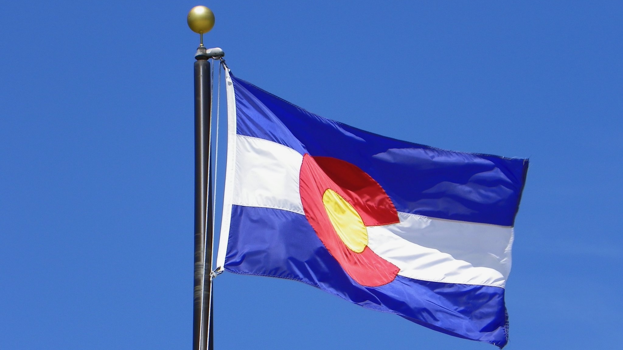 The Colorado state flag flying against a blue sky