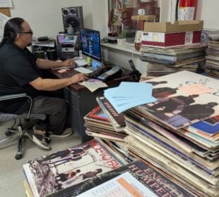 Oitancan “Oi” Zephier, manager of KILI radio in Porcupine, S.D., works on at his computer.
