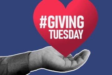 Illustration of a hand holding a red heart imprinted with the words "Giving Tuesday."