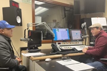 KDNA lead and news director, Francisco Ríos, and community activist Ezequiel Morfín Jr speak on air in one of KDNA's studios