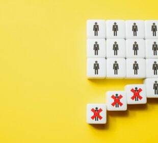 White cubes with stick-figure person icons are arranged in a grid on a bright yellow background. Several cubes have fallen away from the group, and three of them are marked with large red Xs, symbolizing layoffs or people being removed from a workforce
