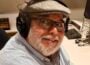 Headshot of KVMR GM Luis Estrada, wearing a gray hat and headphones in a studio