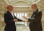 David McCourt, left, and internet pioneer Vint Cerf stand on a balcony inside a grand hall, facing one another as they talk. Cerf gestures with one hand while McCourt listens, with the ornate interior visible in the background.