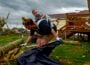 Kaitlyn Robinson picks up storm debris with her daughter, Olivia, strapped to her back in Laurel County, Ky., in May 2025