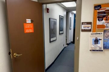 An open door leads into the KTEP-FM studios at the University of Texas at El Paso. A sign identifies the entrance as “206 KTEP FM Studios,” while campus flyers hang on a bulletin board outside the studio hallway.