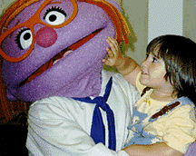 photo of little girl fascinated with person in Muppet suit