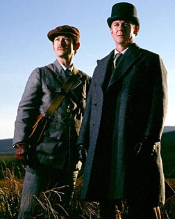 Holmes in high hat surveys the hills for murderers