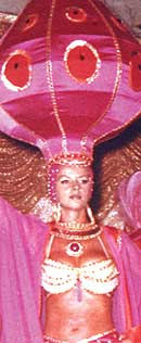 Female dancer wearing  bangles and very large pink exotic hat