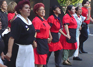 Red-uniformed women grasp hands as they march