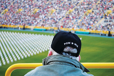 Empty chairs on football field represent war dead and missing  from the state