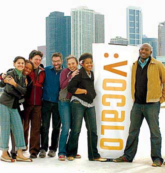 Seven producer-hosts post on rooftop with Vocalo banner