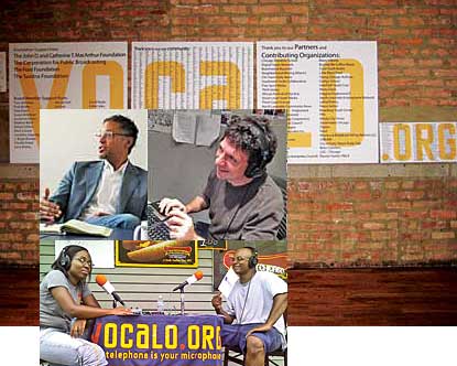 Three Vocalo staffers at work with background of Vocalo logo on brick wall.
